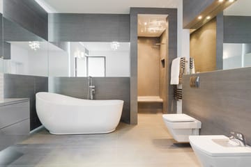 A contemporary bathroom featuring a white toilet and bathtub, designed by a Utah basement builder for modern aesthetics. A contemporary bathroom featuring a white toilet and bathtub, designed by a Utah basement builder for modern aesthetics.