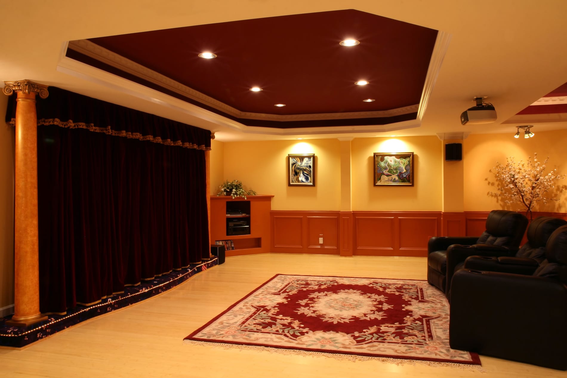 A cozy home theater room featuring a large screen and a comfortable couch, designed by a Utah basement builder.<br />
