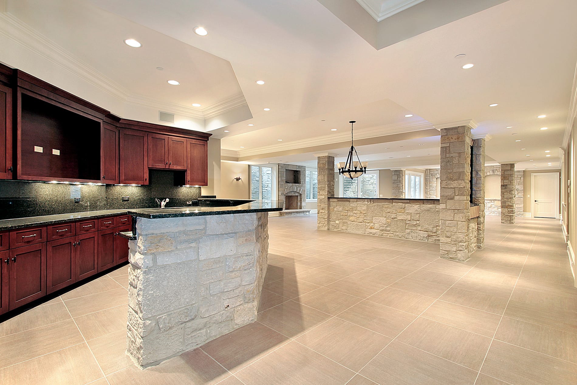  Elegant kitchen showcasing a stone countertop and a large island, crafted by a Utah basement builder for optimal space use.
