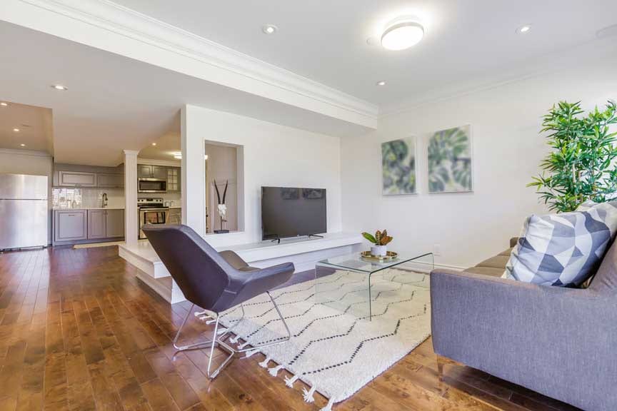 A well-appointed living room with a couch, chair, and television, reflecting the expertise of a Utah basement builder.