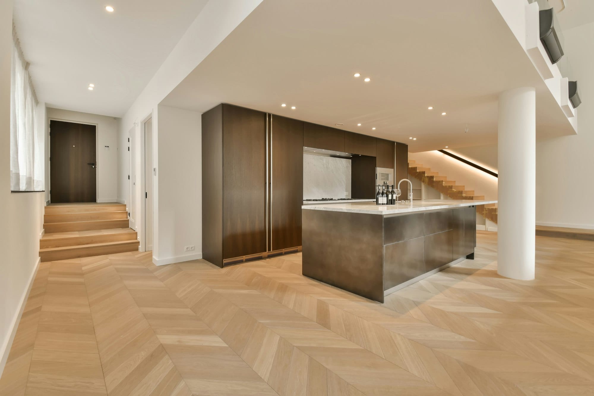 a kitchen with wooden floors and a stainless steel island