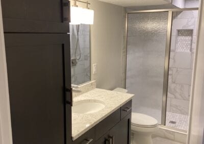 A well-designed bathroom showcasing a shower stall and sink, crafted by a Utah basement builder for functionality and style.