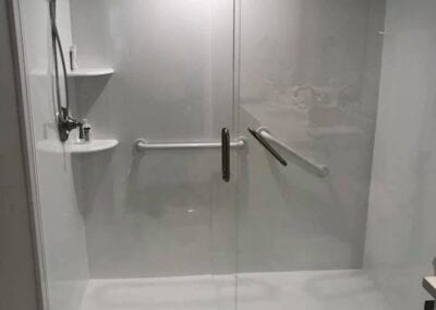 A modern walk-in shower featuring a sleek glass door, designed by a Utah basement builder for a stylish bathroom upgrade.