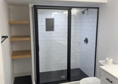 A stylish bathroom with a shower and toilet, expertly constructed by a Utah basement builder to maximize comfort and efficiency.