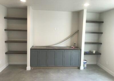 A spacious room showcasing shelves and cabinets, expertly crafted by a Utah basement builder for efficient use of space.