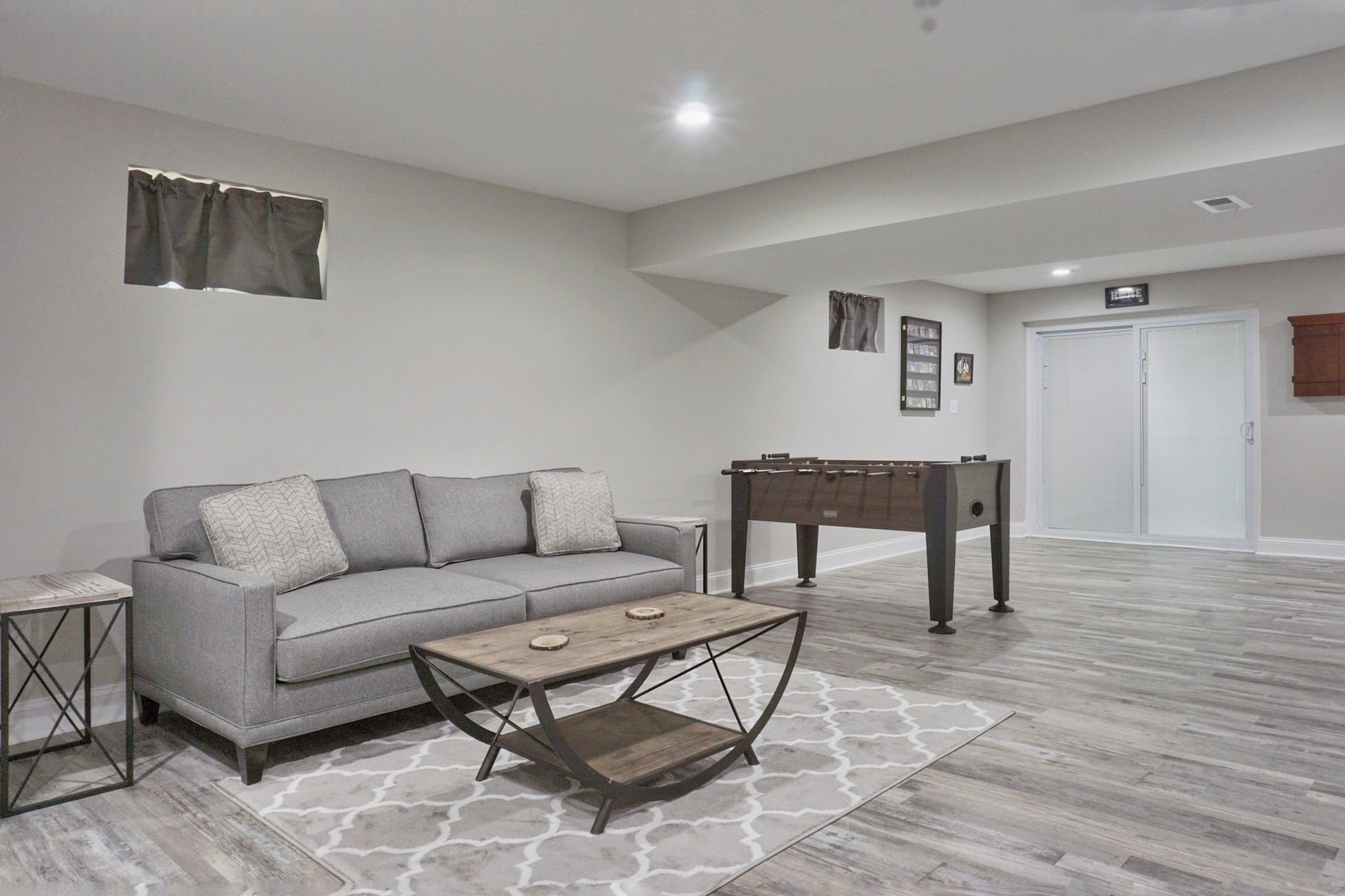  A stylish living room showcasing a couch, coffee table, and a table, crafted by a Utah basement builder for modern living.