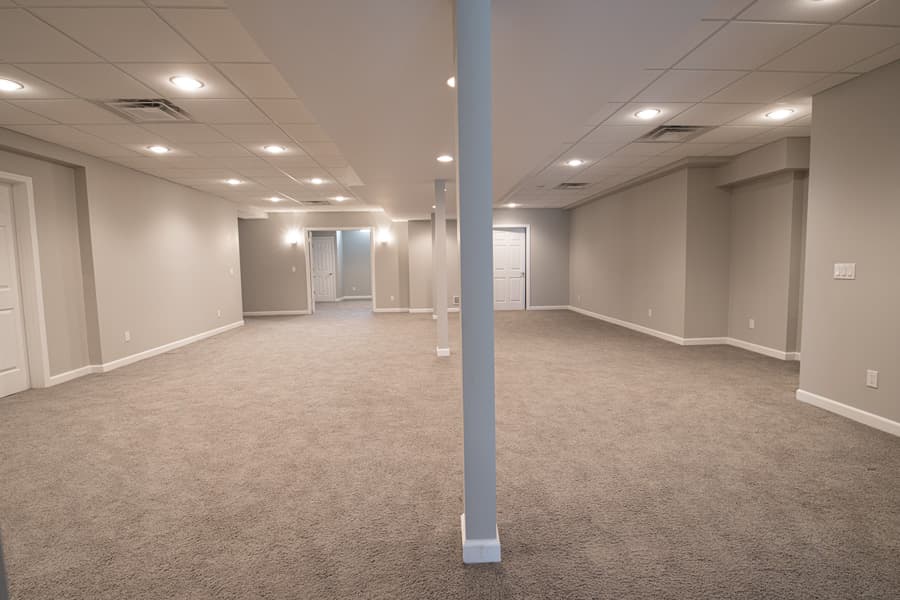 AdobeStock_297623644 Large basement with a modern interior design in bright lighting
